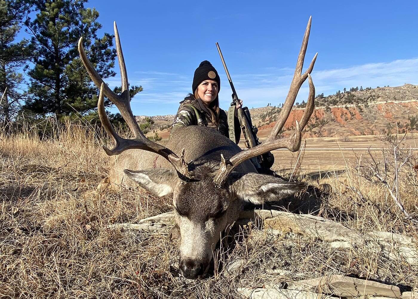 Huntress with a large deer in a natural landscape