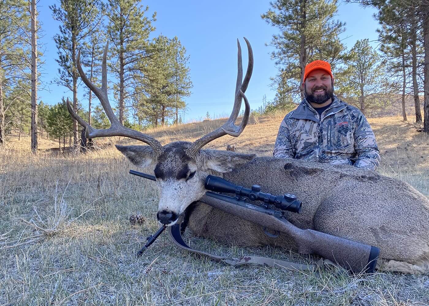 Hunter with a large deer in a forested area